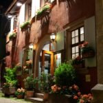 Captivating nighttime view of a flower-adorned building in Riquewihr, France, capturing the charm of the town's streets.
