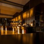 Stylish modern restaurant interior with warm lighting, elegant design, and luxurious ambiance at night.